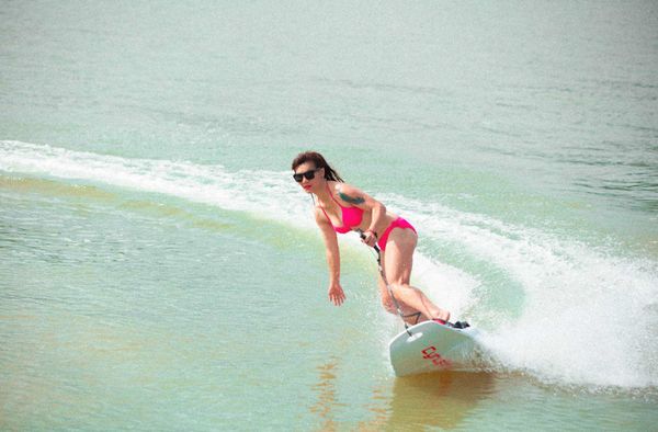 Vrouw surft op elektrische surfboard van Cyrusher.