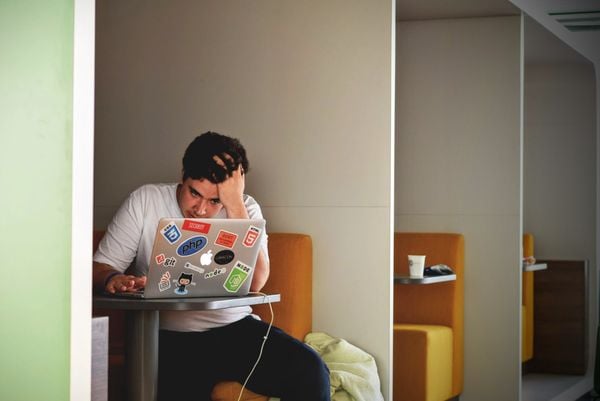 Man achter laptop met stress